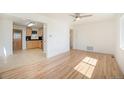 Open-concept living space with gleaming hardwood floors leading to a kitchen area at 1151 Xanthia St, Denver, CO 80220