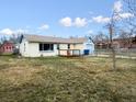 Exterior shot of the property showcasing a wooden deck, well-maintained lawn, and garage at 445 S Depew St, Lakewood, CO 80226