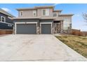 Contemporary two-story home with a three-car garage, stone accents, and spacious concrete driveway at 1995 Wingfeather Ln, Castle Rock, CO 80108