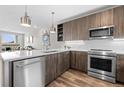 Modern kitchen featuring stainless steel appliances, wood cabinets and a stylish white backsplash at 20 Wilcox St # 318, Castle Rock, CO 80104