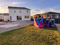 Spacious backyard with lush grass, perfect for outdoor activities and entertaining with an inflatable bounce house at 126 S Vandriver Way, Aurora, CO 80018