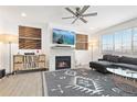 Bright living room features a fireplace, modern ceiling fan, and comfortable gray sectional sofa at 126 S Vandriver Way, Aurora, CO 80018