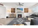 Inviting living room featuring a cozy fireplace, modern ceiling fan, and comfortable sectional sofa at 126 S Vandriver Way, Aurora, CO 80018