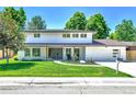 Charming two-story home with a green lawn and easy access from the sidewalk at 6716 W Rowland Ave, Littleton, CO 80128