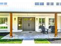Inviting front porch featuring a seating area and stylish gray double-door entrance at 6716 W Rowland Ave, Littleton, CO 80128