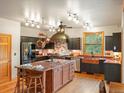 Spacious kitchen with large island, custom range hood, and stainless steel appliances at 28465 Cragmont Dr, Evergreen, CO 80439