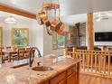 Open-concept kitchen with granite countertops, copper sink, and seamless flow to dining and living areas at 28465 Cragmont Dr, Evergreen, CO 80439