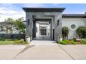 Elegant home featuring a gray stone portico, black metal gate, and manicured landscaping at 96 Glenmoor Ln, Cherry Hills Village, CO 80113