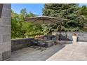 Charming outdoor patio with a fire pit, comfortable seating, and a stylish umbrella for relaxing evenings at 96 Glenmoor Ln, Cherry Hills Village, CO 80113
