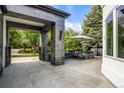 Stone patio area with built in seating, a fire pit, umbrella and mature trees at 96 Glenmoor Ln, Cherry Hills Village, CO 80113