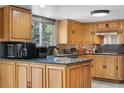 Spacious kitchen showcasing wooden cabinets, stainless steel appliances, granite countertops, and a window at 1758 S Tucson St, Aurora, CO 80012