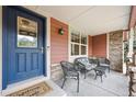 Inviting covered front porch with seating area, decorative door, and exterior stone accents at 5810 Moss Ct, Golden, CO 80403