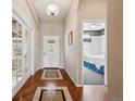 Well-lit hallway featuring hardwood floors, a decorative light fixture, and access to other rooms at 5810 Moss Ct, Golden, CO 80403