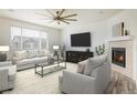 Cozy living room with a fireplace, ceiling fan, and large window offering natural light at 9283 Sedalia St, Commerce City, CO 80022