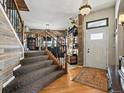 Inviting foyer with hardwood floors, staircase with wood and iron railings, and stylish chandelier at 10273 Salida St, Commerce City, CO 80022