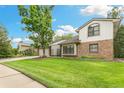 Well-maintained lawn and landscaping complement the brick and siding of this two-story home at 8474 E Otero Cir, Centennial, CO 80112