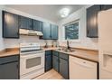 Galley kitchen with white appliances, wood countertops, and modern cabinetry at 16179 E Rice Pl # B, Aurora, CO 80015