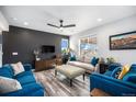 Cozy living room with a dark accent wall, ample seating, and lots of natural light from the windows at 1616 Metcalf Dr, Erie, CO 80516