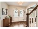 Elegant entryway with wood floors, double doors, and staircase at 7708 S Krameria Ct, Centennial, CO 80112