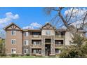Three-story condo building featuring stone accents, private balconies and well-maintained landscaping at 8039 Lee Dr # 2, Arvada, CO 80005