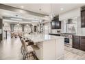 Open kitchen layout with stainless appliances, island with seating, and pendant lighting at 1815 Avery Way, Castle Rock, CO 80109