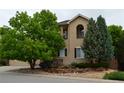 Charming two-story home with a stucco facade, stone accents and mature landscaping at 2819 Canyon Crest Dr, Highlands Ranch, CO 80126