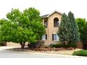 Charming two-story home with stucco exterior and mature landscaping at 2819 Canyon Crest Dr, Highlands Ranch, CO 80126