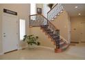 Grand foyer showcasing a staircase with decorative iron railings and neutral tile flooring at 2819 Canyon Crest Dr, Highlands Ranch, CO 80126