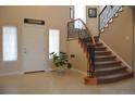 Elegant foyer with tile flooring, staircase with iron railing, and bright natural light from windows around the front door at 2819 Canyon Crest Dr, Highlands Ranch, CO 80126