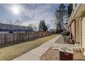 Private fenced backyard with a well-manicured lawn and a row of air conditioning units at 8300 S Upham Way, Littleton, CO 80128