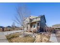 Landscaped front yard featuring a well-maintained lawn, mature trees, and a charming home exterior at 7899 S Country Club Pkwy, Aurora, CO 80016