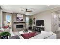 Inviting living room features a tiled fireplace, modern ceiling fan, and neutral tones that create a welcoming ambiance at 9186 Telluride Ct, Commerce City, CO 80022