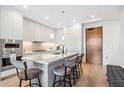 Bright kitchen featuring a marble island, pendant lighting, modern appliances, and wood door at 1901 Wazee St # 504, Denver, CO 80202