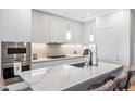 Close up of a kitchen island with stainless steel appliances and sleek white cabinets at 1901 Wazee St # 504, Denver, CO 80202