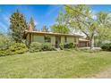 Charming home featuring a lush front lawn, mature trees, and a welcoming facade at 13955 W 26Th Ave, Golden, CO 80401