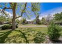 Landscaped front yard with lush lawn and mature trees, offering great curb appeal at 13955 W 26Th Ave, Golden, CO 80401