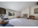 Spacious living room with a fireplace, large window, and neutral carpet at 13955 W 26Th Ave, Golden, CO 80401