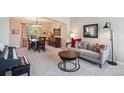 Comfortable living room with neutral-toned furniture, carpet, and stylish décor adjacent to the dining area at 4175 S Andes St, Aurora, CO 80013