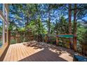 Outdoor deck surrounded by lush greenery and mature trees, offering a private and serene outdoor living space at 5416 S Hannibal Ct, Centennial, CO 80015