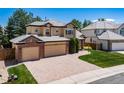 Beautiful two-story home featuring a three-car garage, brick accents, and a well-manicured front yard and brick paver driveway at 5416 S Hannibal Ct, Centennial, CO 80015