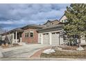 Charming home featuring a two-car garage, brick accents, and professionally landscaped grounds at 10526 Fairhurst Way, Highlands Ranch, CO 80126