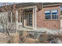 Inviting front porch with brick accents, a modern front door, and decorative landscaping at 10526 Fairhurst Way, Highlands Ranch, CO 80126