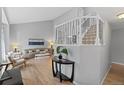 Bright foyer with a view into the living room featuring a staircase and hardwood floors at 5310 S Flanders Way, Centennial, CO 80015
