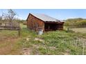 Rustic wooden barn with a weathered exterior, nestled in a tranquil, grassy setting at 2938 Wolfensberger Rd, Sedalia, CO 80135