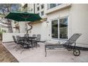 Outdoor patio features metal furniture, including table, chairs, and lounge, with a green umbrella at 6617 S Forest Way # E, Centennial, CO 80121