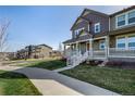 Two-story house featuring a welcoming front porch, showcasing a home's design and curb appeal at 3534 N Meadows Dr, Castle Rock, CO 80109
