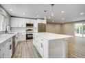 Spacious kitchen with a large island, modern appliances, pendant lights, and ample cabinet space at 363 Lima St, Aurora, CO 80010