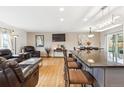 Open-concept living area with hardwood floors, recessed lighting, and a kitchen island at 9379 W Burgundy Ave, Littleton, CO 80123