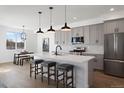 Modern kitchen features grey cabinets, stainless steel appliances, and a large island with bar stool seating at 4650 W 9Th Ave, Denver, CO 80204