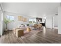 Open concept living room featuring modern decor, wood floors and plenty of natural light at 18645 E 54Th Pl, Denver, CO 80249